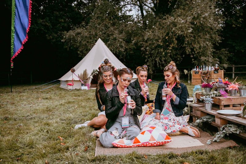 Girls at festival hen party sitting on rug