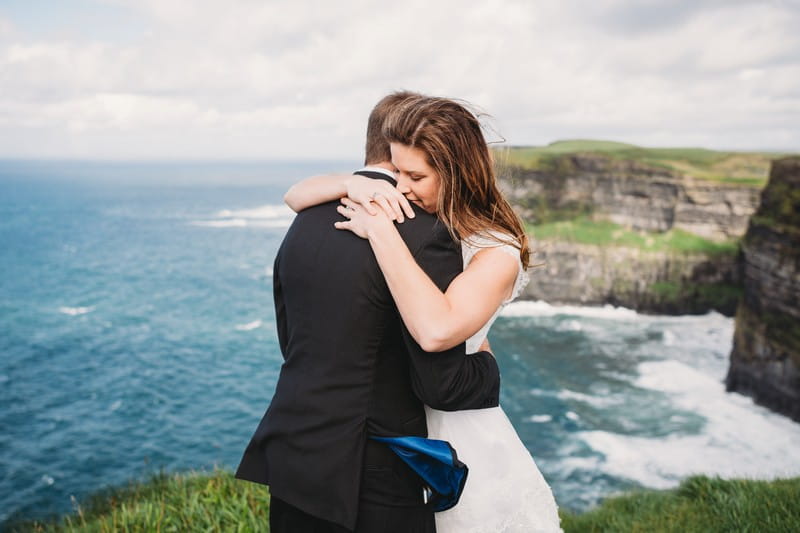 Bride and groom hugging in front of sea - Picture by Lisa Lander Photography