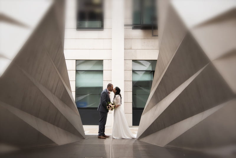 Bride and groom kissing in middle of modern architecture - Picture by Carla Thomas Photography