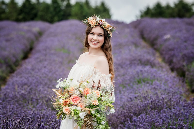 Smiling bride wearing flower crown in field of lavender