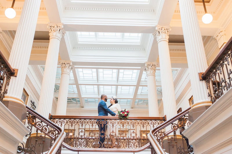 Bride and groom at top of stairs at wedding venue