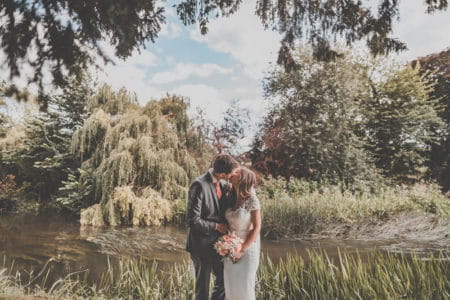 Bride and groom kissing in front of stream - Picture by Michelle Lindsell Photography