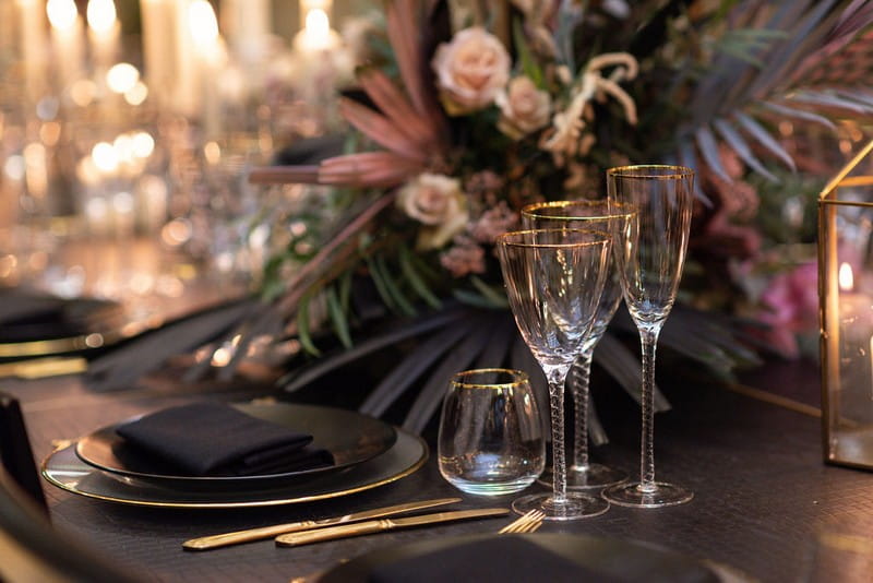 Glasses and large floral display on wedding table