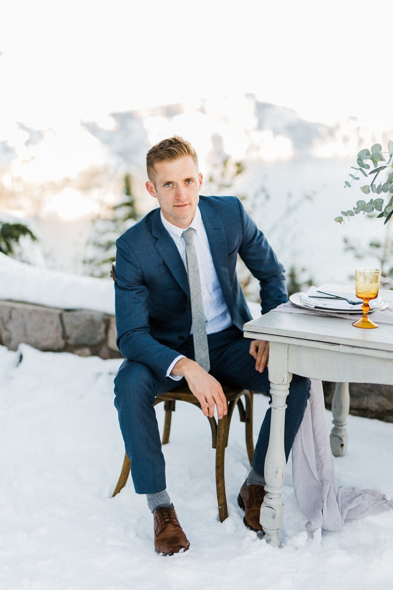 Groom sitting at table in the snow