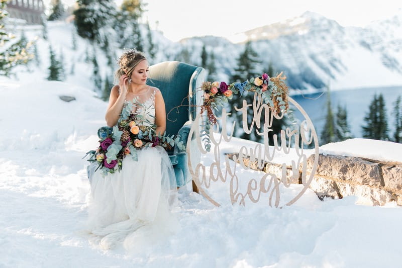 Bride sitting on blue armchair in snow