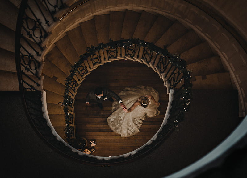 Bride and groom at bottom of spiral staircase - Picture by Oobaloos Photography