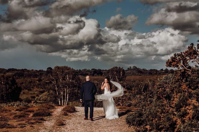 Bride and groom walking on path in countryside - Picture by Romy Lawrence Photography