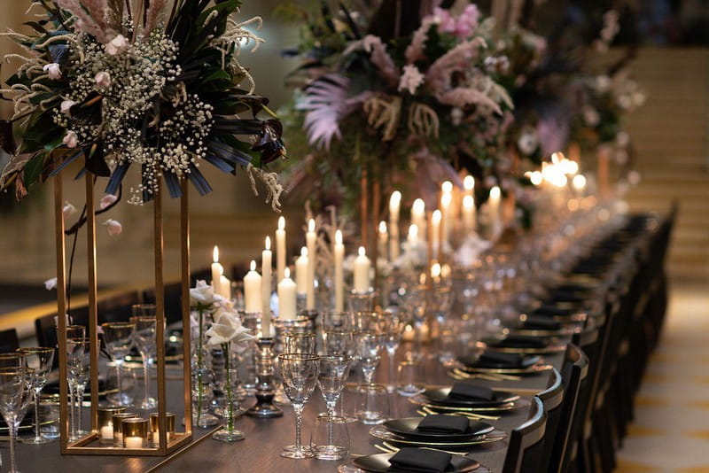 Statement floral displays and candles on long wedding table