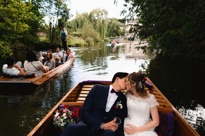 Bride and groom kissing on boat on river - Picture by Sam Gibson Photography