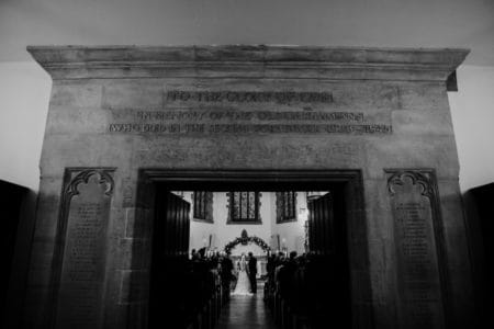 Picture taken through entrance of church of wedding ceremony taking place inside - Picture by BGS Weddings