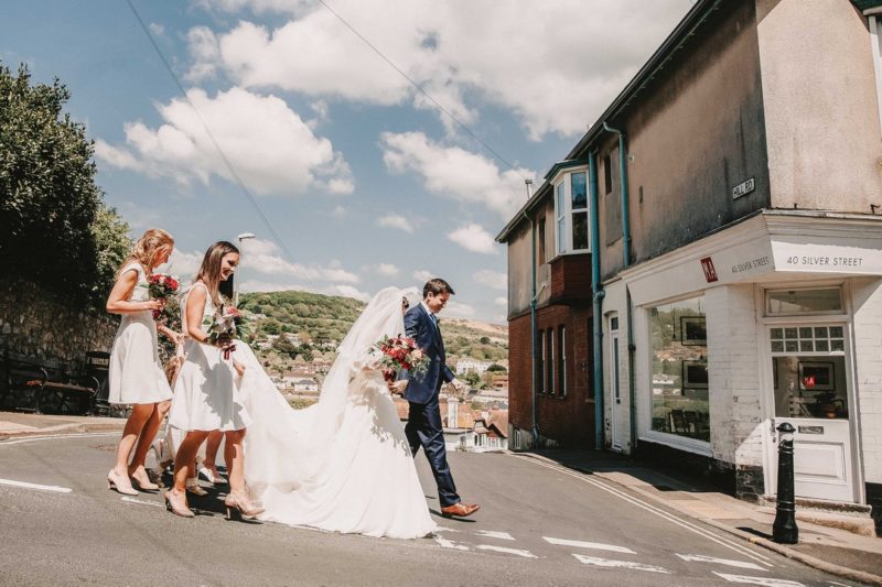 Wedding party walking down road in Lyme Regis