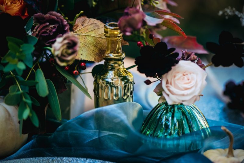 Coloured glass bottles on wedding table