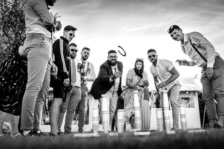 Groom throwing horseshoe during wedding lawn game - Picture by Linus Moran Photography