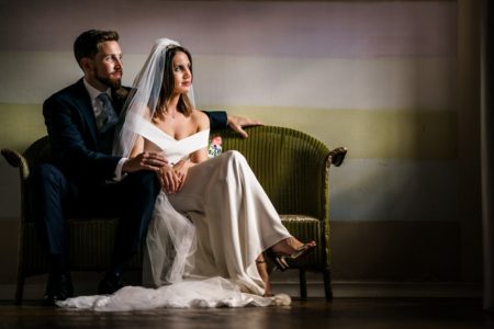 Bride and groom sitting on green chair - Picture by Rob Dodsworth Photography