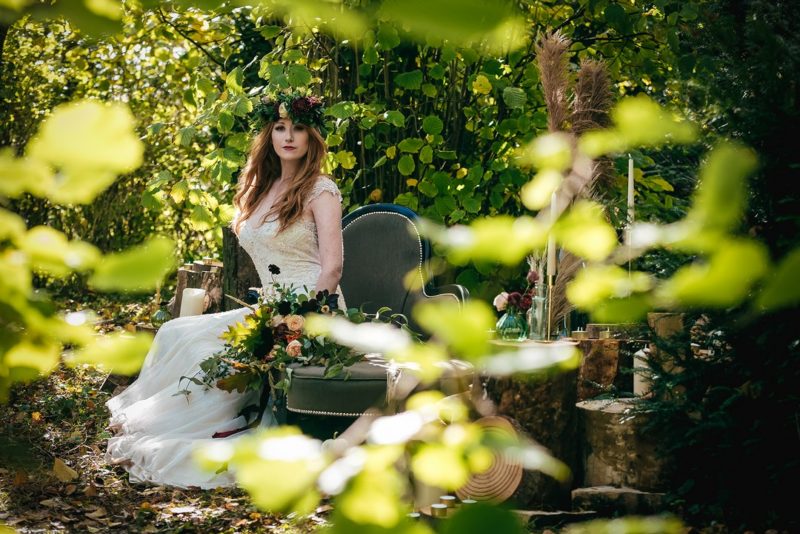 Bride sitting on chez lounge in woods