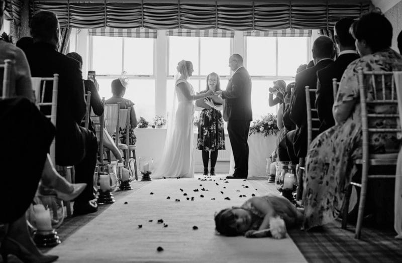 Young girl laying on floor during wedding ceremony