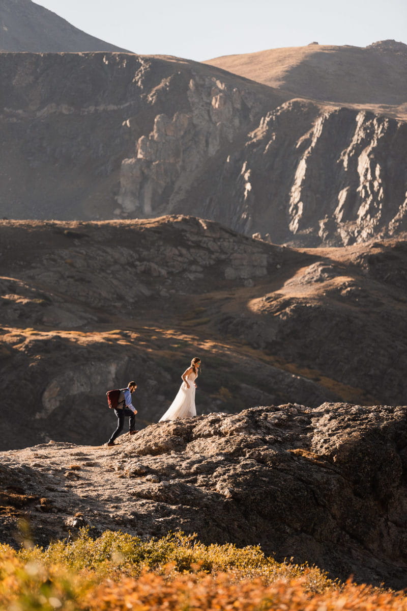 Bride and groom walking up mountain - Picture by The Drawhorns