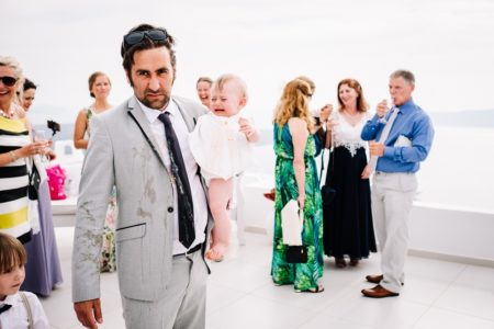 Cross man with comit on him carrying baby out of room at wedding - Picture by Anesta Broad Photography