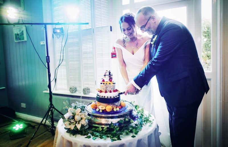 Bride and groom cutting cheese stack cake