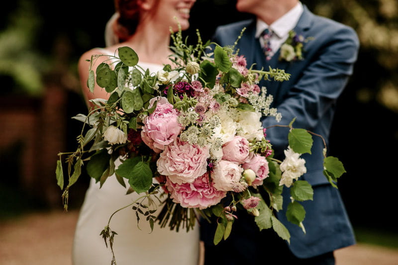 Bride and groom holding oversized wedding bouquet - Picture by Jessy Papasavva Photography