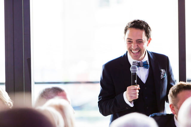 Groom using microphone for wedding speech