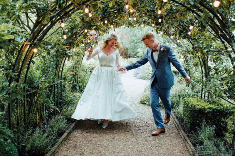 Bride and groom dancing under foliage-covered walkway - Picture by Nathan Walker Photography