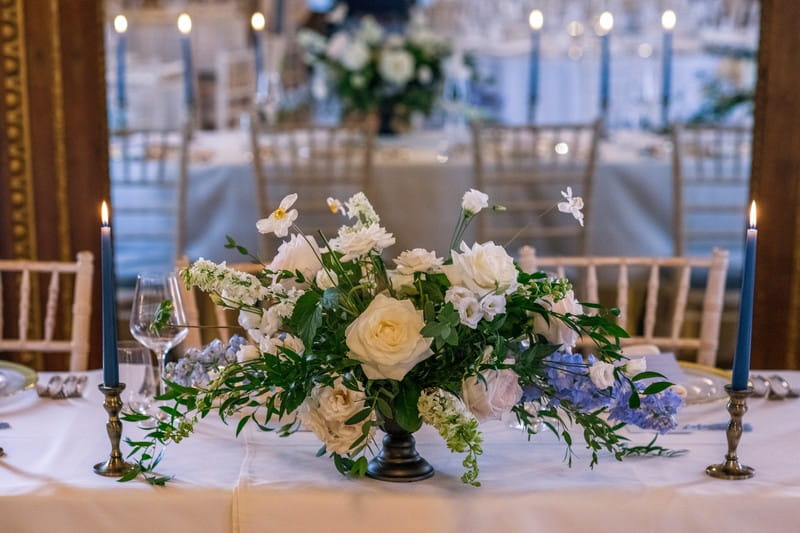 Floral wedding table display with blue and white flowers and foliage