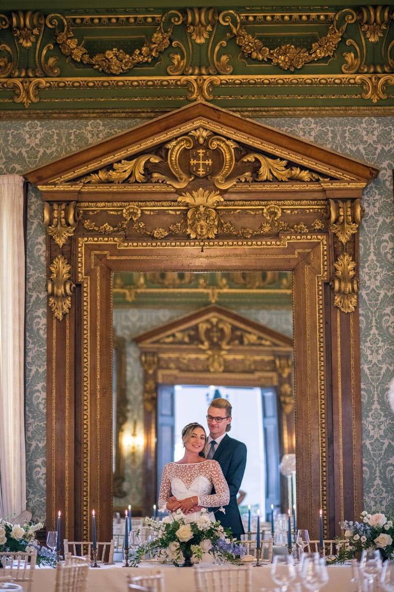 Bride and groom standing in front of mirror in The Ballroom at Hawkstone Hall
