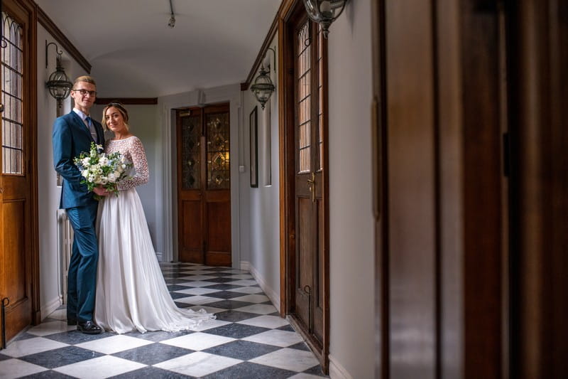 Bride and groom in corridor of Hawkstone Hall