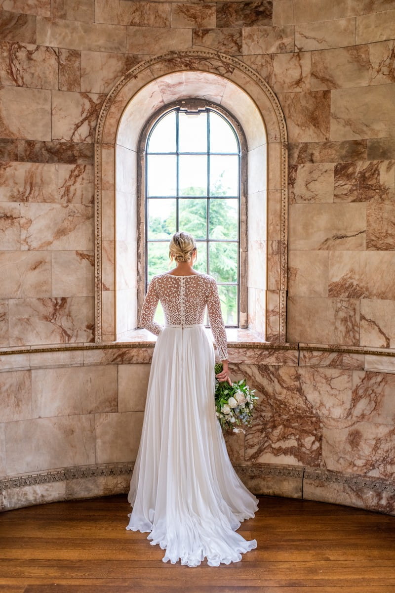 Bride looking out of window of The Tapestry Room at Hawkstone Hall