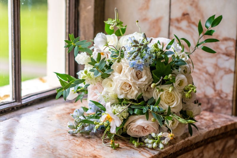 Bridal bouquet with ivory and blue flowers and green foliage