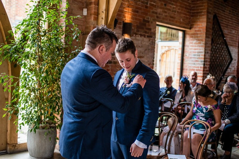 Best man helping groom with buttonhole