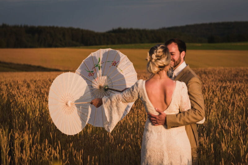 Bride and groom holding parasols with their shadows on - Picture by Carine Bea