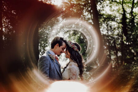 Bride and groom touching heads surrounded by swirl of light from camera lens - Picture by Gina Fernandes Photography