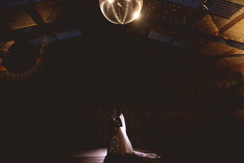 Bride and groom first dance in dark under glitter ball - Picture by Katie Sidell Photography