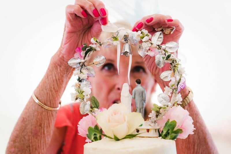 Grandmother adding decoration to wedding cake topper - Picture by Married to my Camera