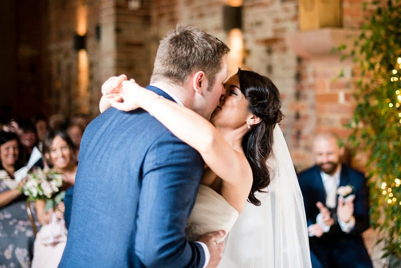 Bride and groom kiss at end of wedding ceremony