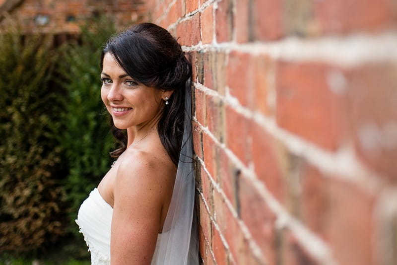 Bride standing with back to wall