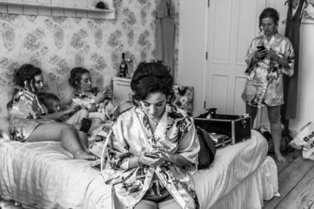 Bridesmaids all looking at their phones during bridal prep - Picture by Piccolino Weddings