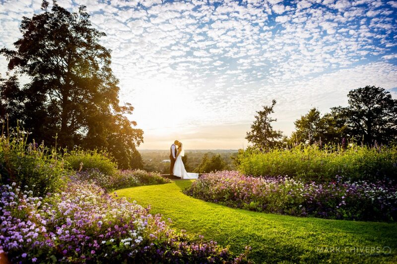 Bride and groom in beautiful garden with blue sky and clouds above - Picture by Mark Chivers Photography