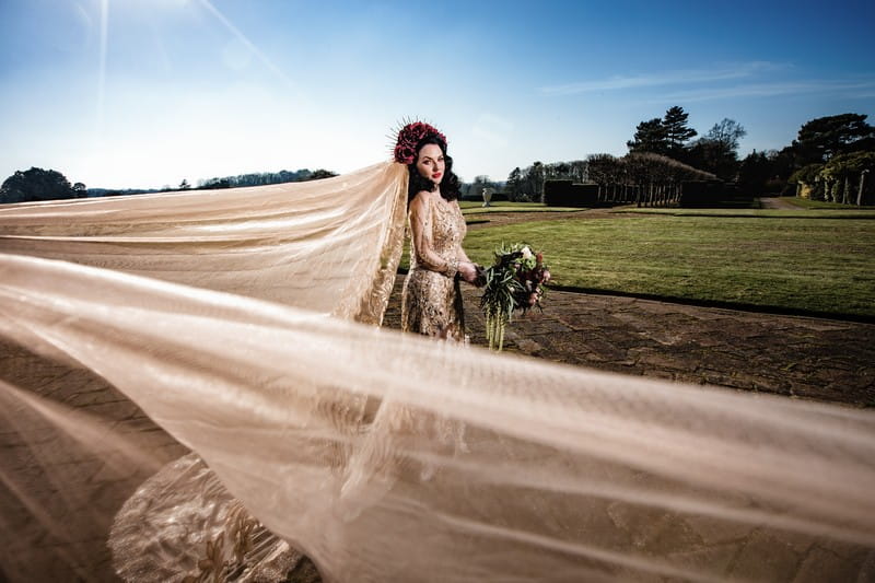 Bride's large veil blowing in wind behind her
