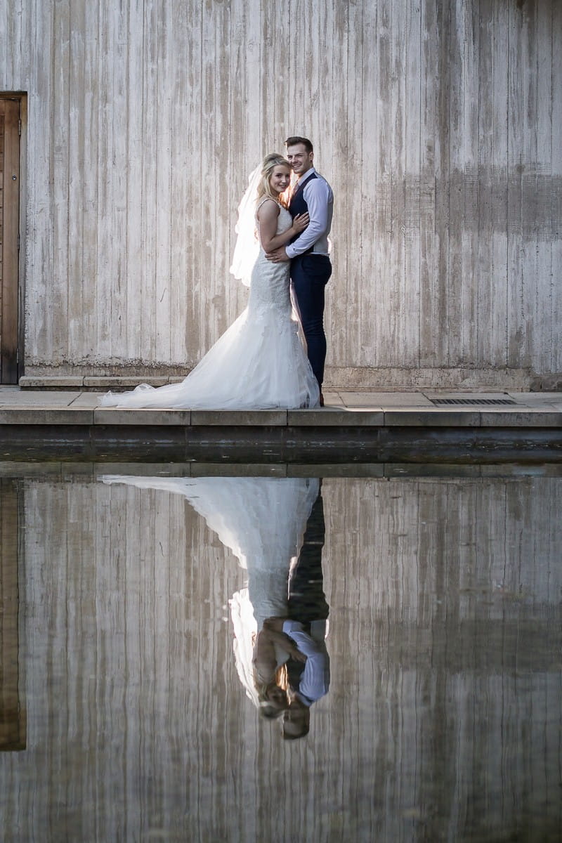 Bride and groom with reflection in water