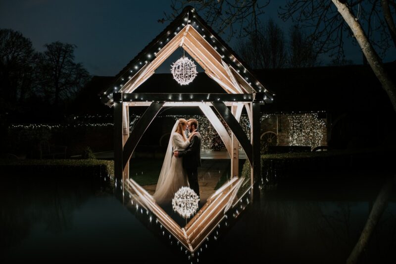 Bride and groom touching heads below canopy with reflection below - Picture by Michelle Cordner Photography