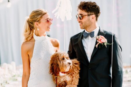 Bride and groom wearing sunglasses and holding a dog - Picture by Jessy Papasavva Photography