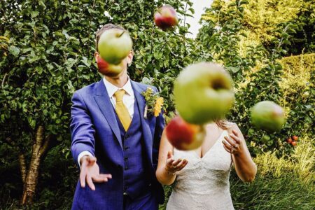 Bride and groom throwing apples at camera - Picture by Steven Rooney Photography