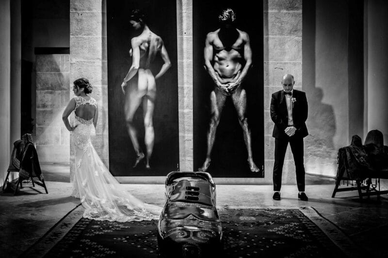 Bride and groom copying poses from pictures behind them - Picture by Graham Warrellow Photography