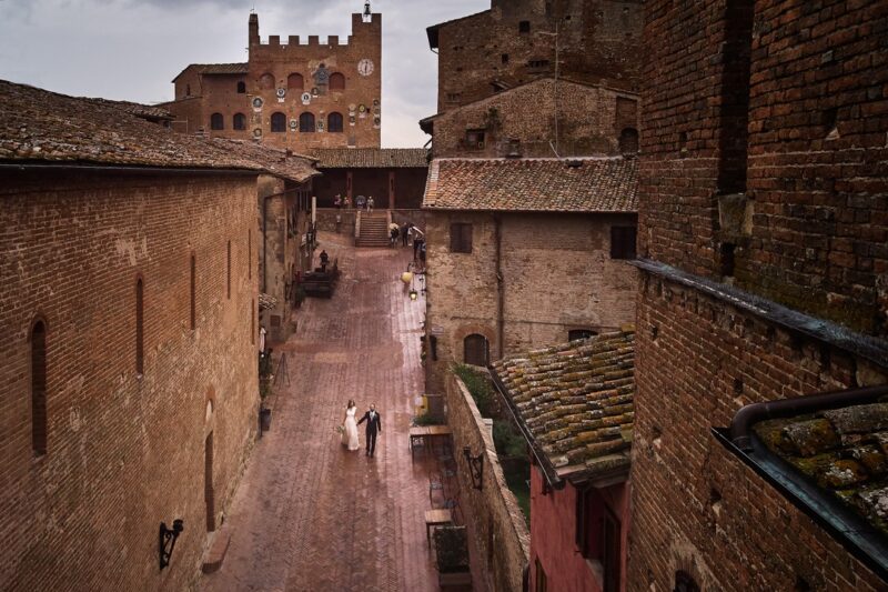 Bride and groom walking down street in Tuscany - Picture by D2 Photography