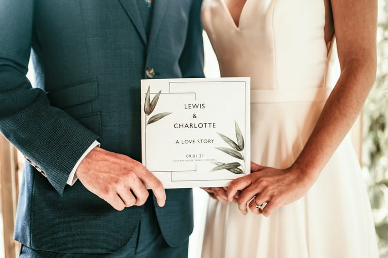 Bride and groom holding Love Story booklet by CherryTop Weddings