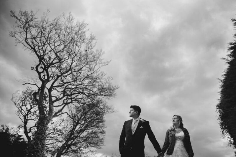 Bride and groom holding hands between trees - Picture by IG Time Photography