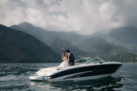 Bride and groom on speedboat with hills in background - Picture by Daniel López Pérez